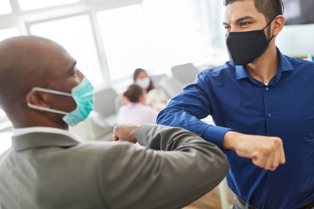 socially distanced elbow bump greeting employee wellbeing