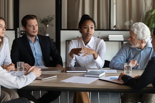 age diverse workforce sitting round a table.