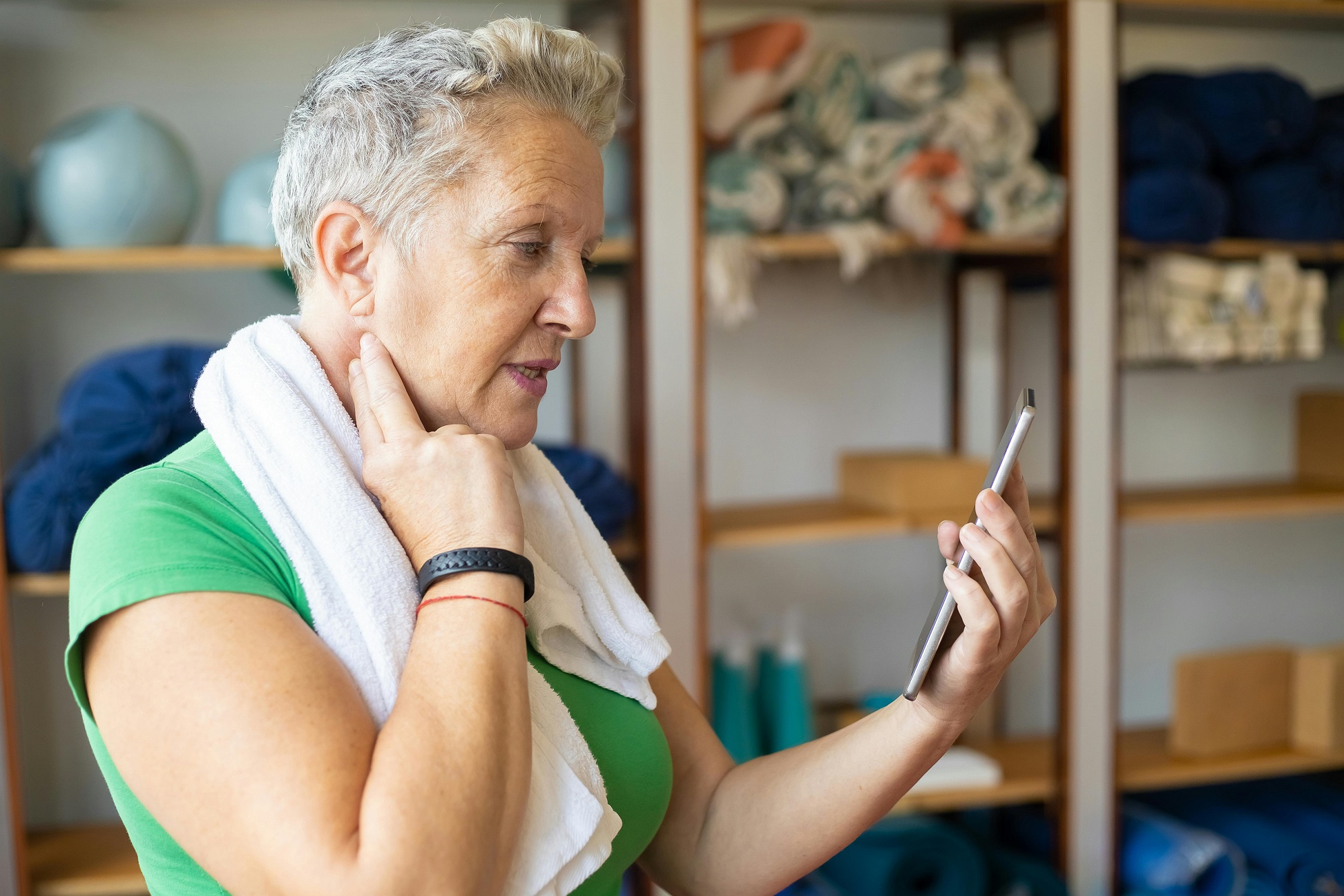 lady using preventative digtal health solution on mobile phone whilst checking pulse in neck